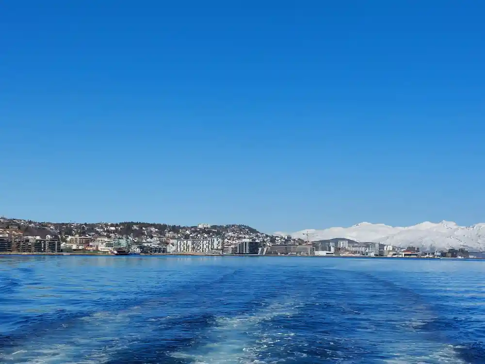 Coastal city with mountains across blue water