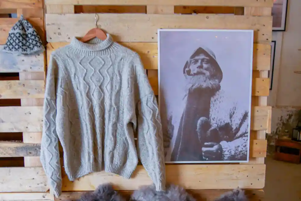 Gray knitted sweater and portrait photograph on wooden display