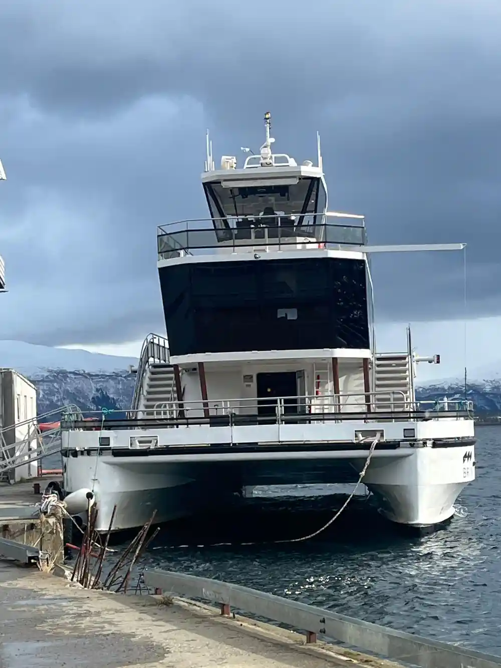 Large white and black fishing vessel moored at harbor dock