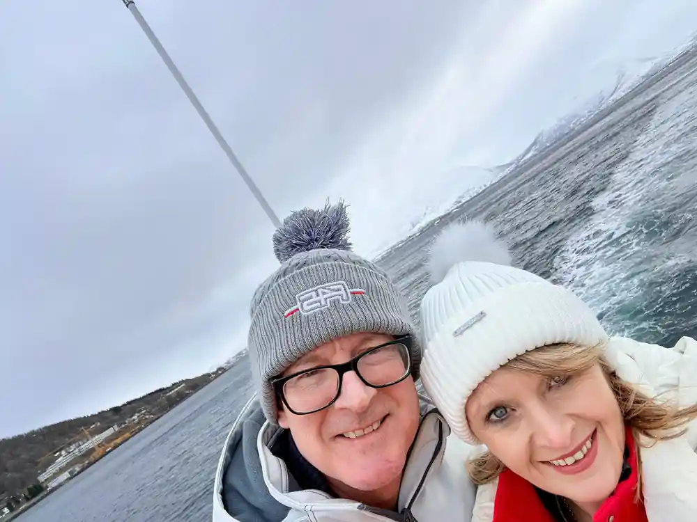 Man and woman smiling outdoors wearing winter hats