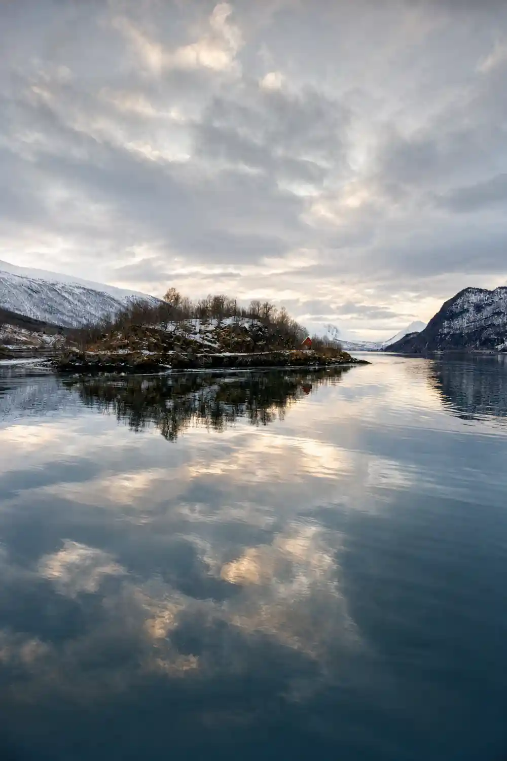 Snow-covered mountains reflected in still lake water