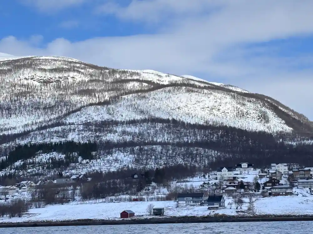 Snowy village nestled at foot of large mountain