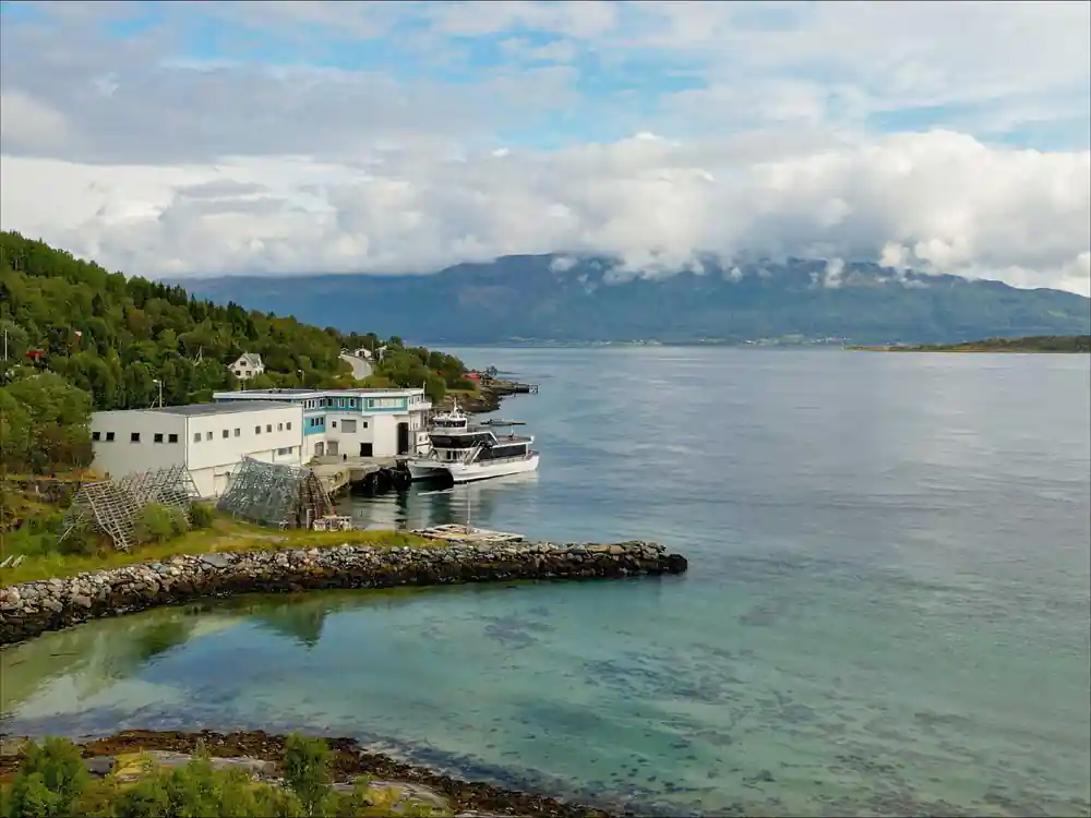 Waterside industrial building with mountains across water